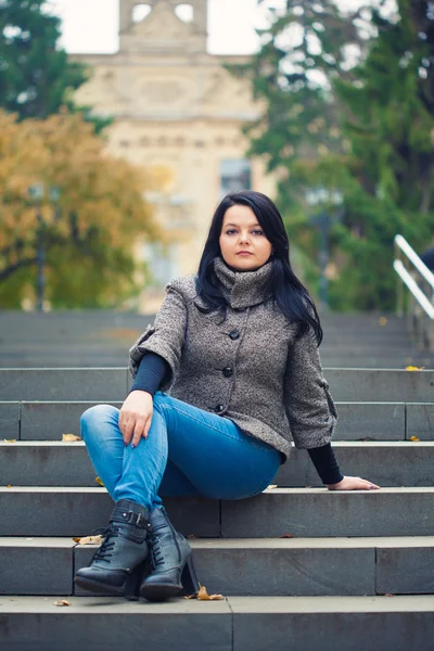 Une fille assise sur un escalier en pierre — Photo