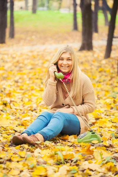 Jovem mulher falando no telefone vintage no parque de outono — Fotografia de Stock