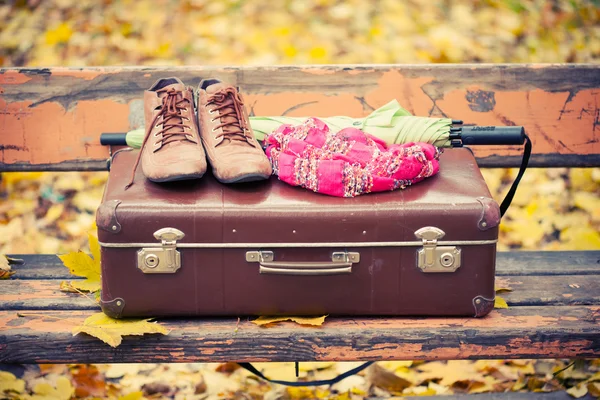 Rocznika walizki, szalik, buty i parasol na ławce — Zdjęcie stockowe