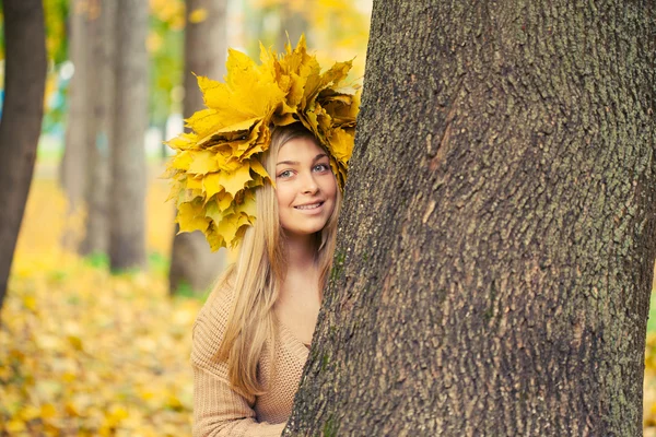 Mladá žena nosí věnec podzimní listí — Stock fotografie