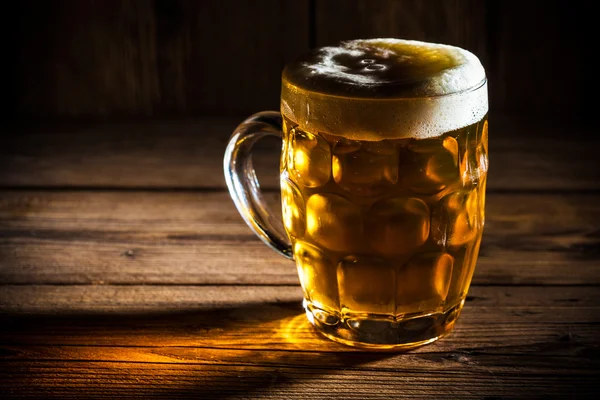 Кружка пива на деревянном фоне — стоковое фото