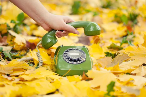 Hand hält Oldtimer-Handyhörer im Herbstpark — Stockfoto