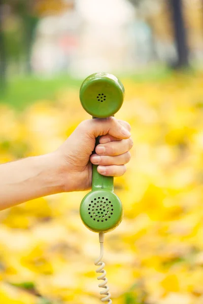 Hand hält Oldtimer-Handyhörer im Herbstpark — Stockfoto