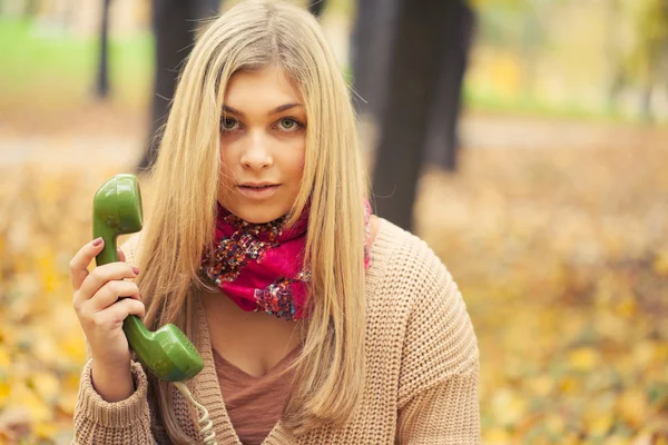 Genç kadın vintage telefon sonbahar Park söz — Stok fotoğraf