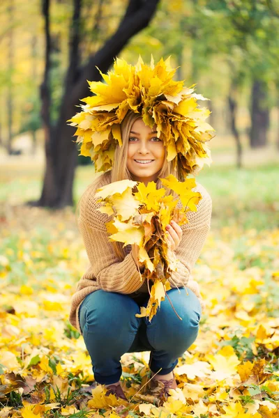 Νεαρή γυναίκα, φορώντας ένα στεφάνι του φθινοπώρου φύλλα — Φωτογραφία Αρχείου