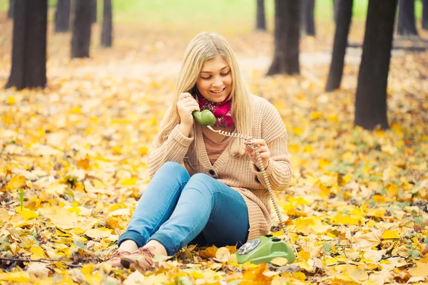 Νεαρή γυναίκα που μιλάμε για vintage τηλέφωνο στο πάρκο φθινόπωρο — Φωτογραφία Αρχείου