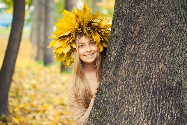 Jonge vrouw dragen een krans van de herfst bladeren — Stockfoto