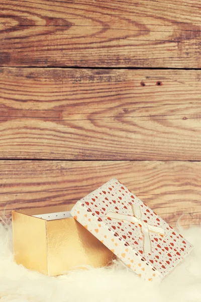 Boîte cadeau avec fourrure blanche sur fond en bois — Photo