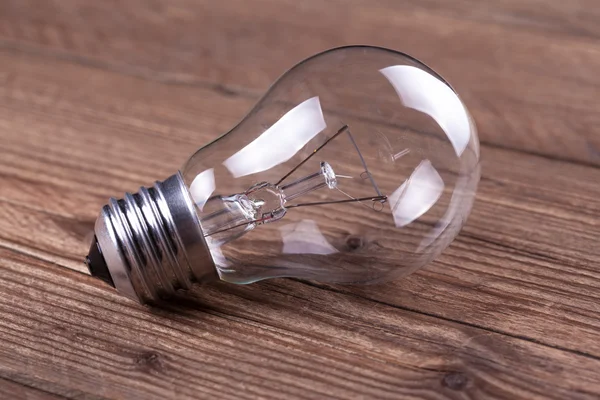 Bulb on the brown wooden background — Stock Photo, Image