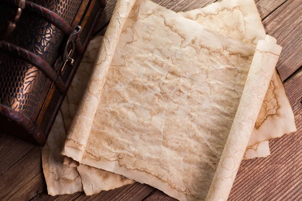 Старая бумага на деревянном фоне с винтажным сундуком — стоковое фото