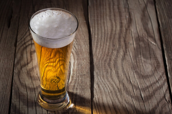 Mug of beer on wooden background