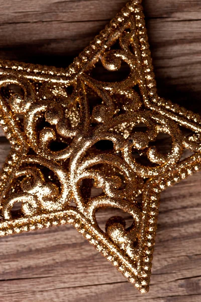 Golden christmas star on wooden background — Stock Photo, Image