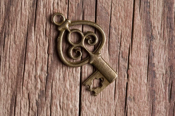 Single key on wooden background — Stock Photo, Image