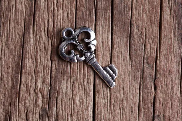 Single key on wooden background — Stock Photo, Image