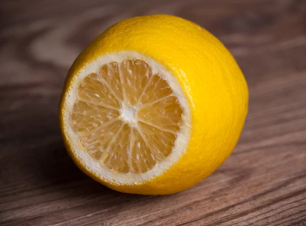 Один лимон на деревянном фоне — стоковое фото