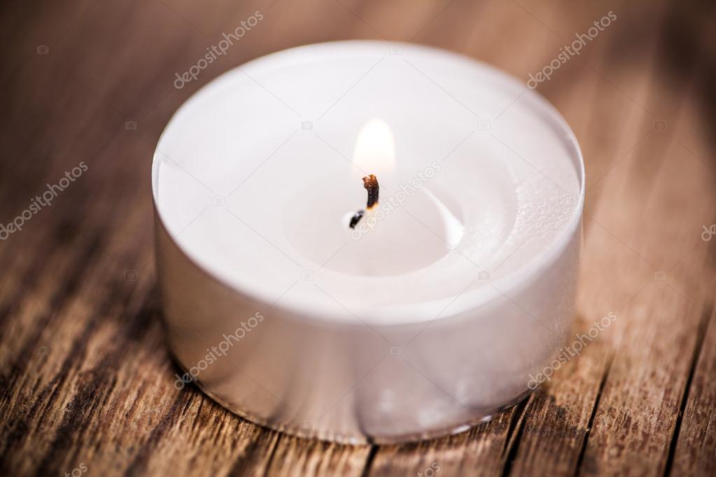 Candle on wooden background