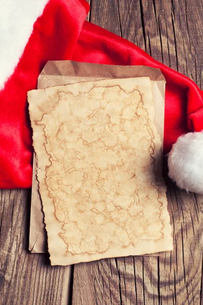 กระดาษวินเทจกับหมวกของซานต้า — ภาพถ่ายสต็อก