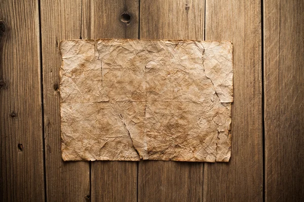 Старая бумага на деревянном фоне — стоковое фото