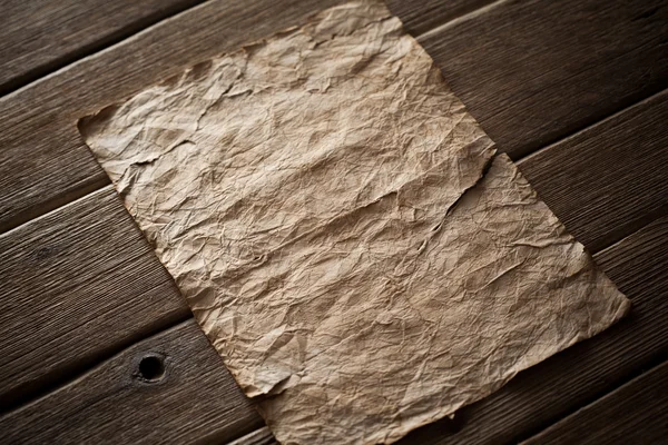Старая бумага на деревянном фоне — стоковое фото