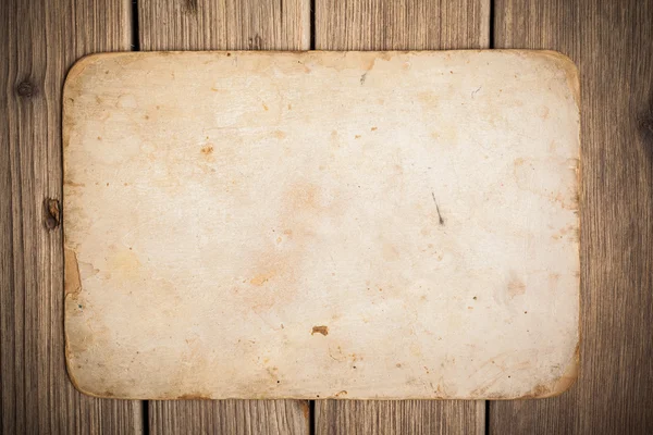 Papel velho sobre o fundo de madeira — Fotografia de Stock