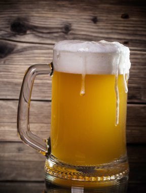 Ahşap arka planda cam bira 