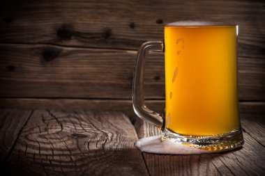 Ahşap arka planda cam bira 