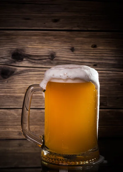 Скляне пиво на фоні дерева — стокове фото
