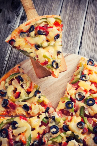 Deliciosa pizza italiana servida sobre mesa de madera — Foto de Stock