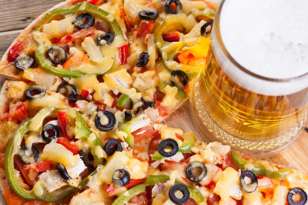 Pizza en la mesa con un vaso de cerveza — Foto de Stock