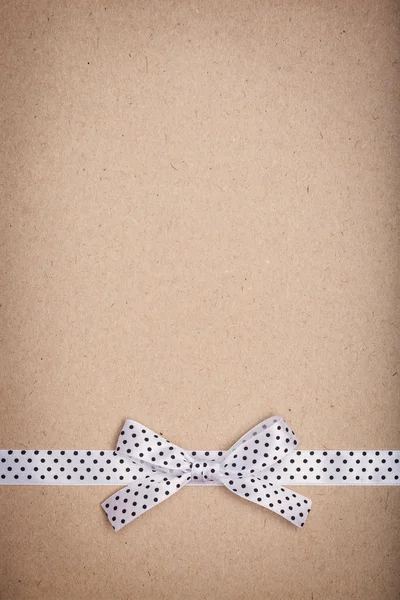 Ribbon and bow on old paper — Stock Photo, Image