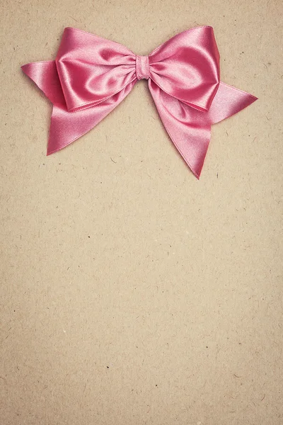 Pink bow on old paper — Stock Photo, Image