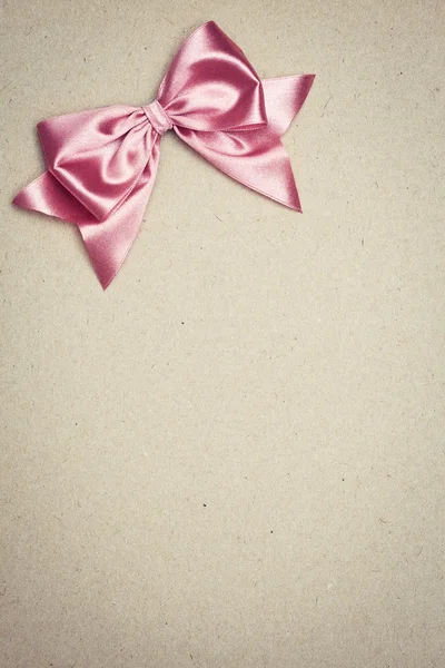 古い紙の上にピンクの弓 — ストック写真