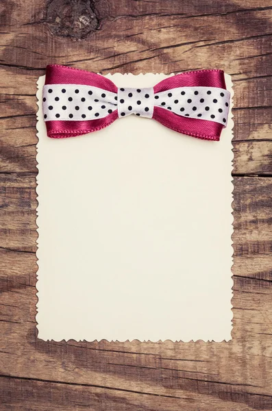 Blanco papier blad met roze boog — Stockfoto