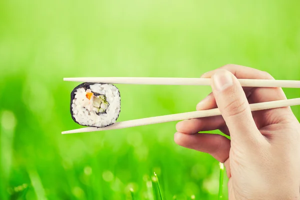 Hand met sushi roll — Stockfoto