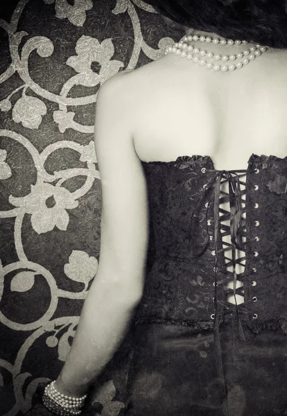 Žena nosí černý korzet a perly — Stock fotografie