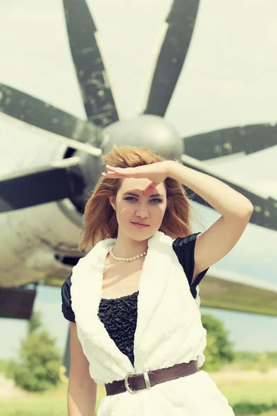 Woman posing against plane — Stock Photo, Image