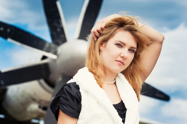 Piękna kobieta pozowanie przed samolotem — Zdjęcie stockowe