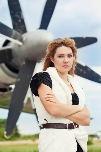 Жінка позує проти літака — стокове фото