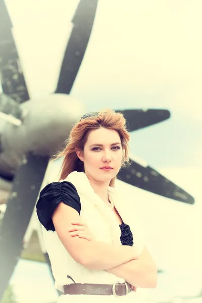 Woman posing against plane — Stock Photo, Image