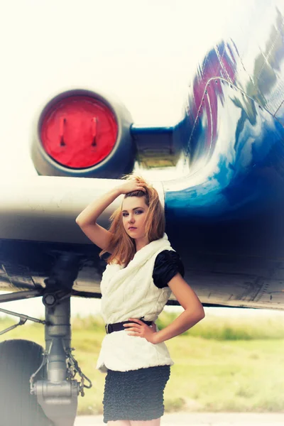 Schöne Frau posiert in der Nähe von Flugzeug — Stockfoto
