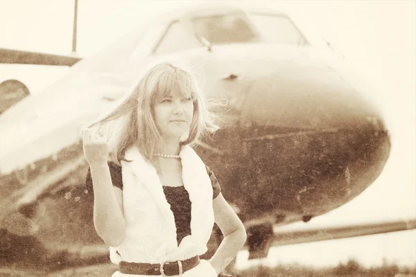 Hermosa mujer posando cerca de avión — Foto de Stock