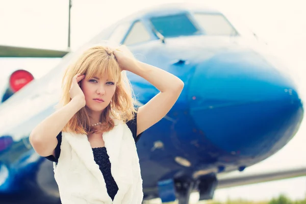 Beautiful woman posing near plane — Stock Photo, Image