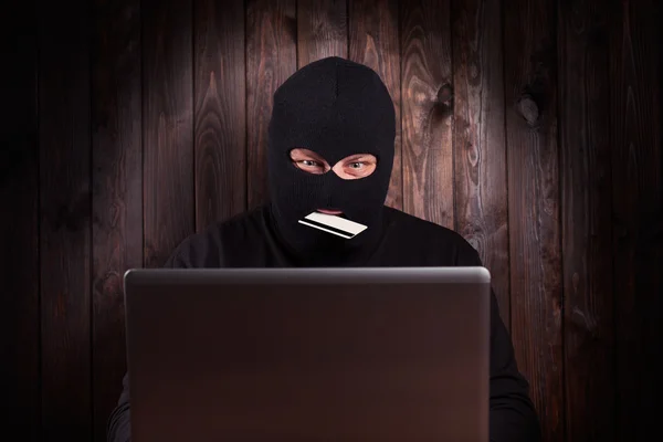 Hacker holding a credit card — Stock Photo, Image