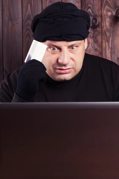 Hacker holding a credit card — Stock Photo, Image