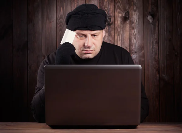 Hacker holding a credit card — Stock Photo, Image