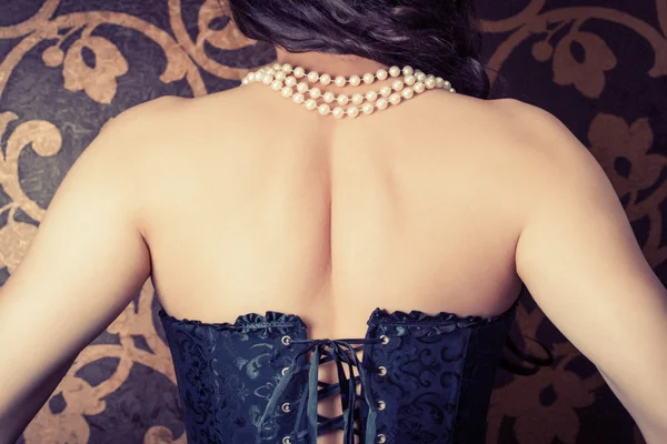 Donna con corsetto nero e perle — Foto Stock