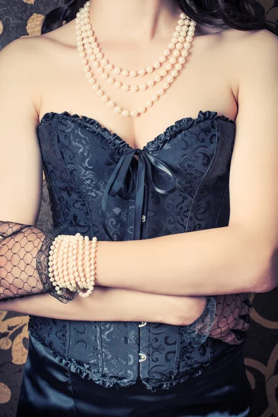 Kvinna som bär svart korsett och pärlor — Stockfoto