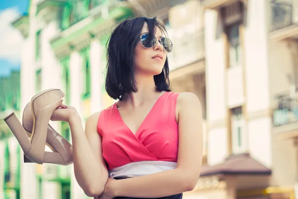 Mujer sosteniendo un par de zapatos —  Fotos de Stock