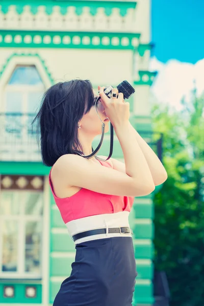 Mulher tirando fotos com câmera vintage — Fotografia de Stock