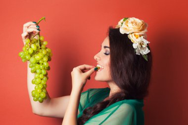 çelenk takmış ve Yeşil üzüm tutan kadın